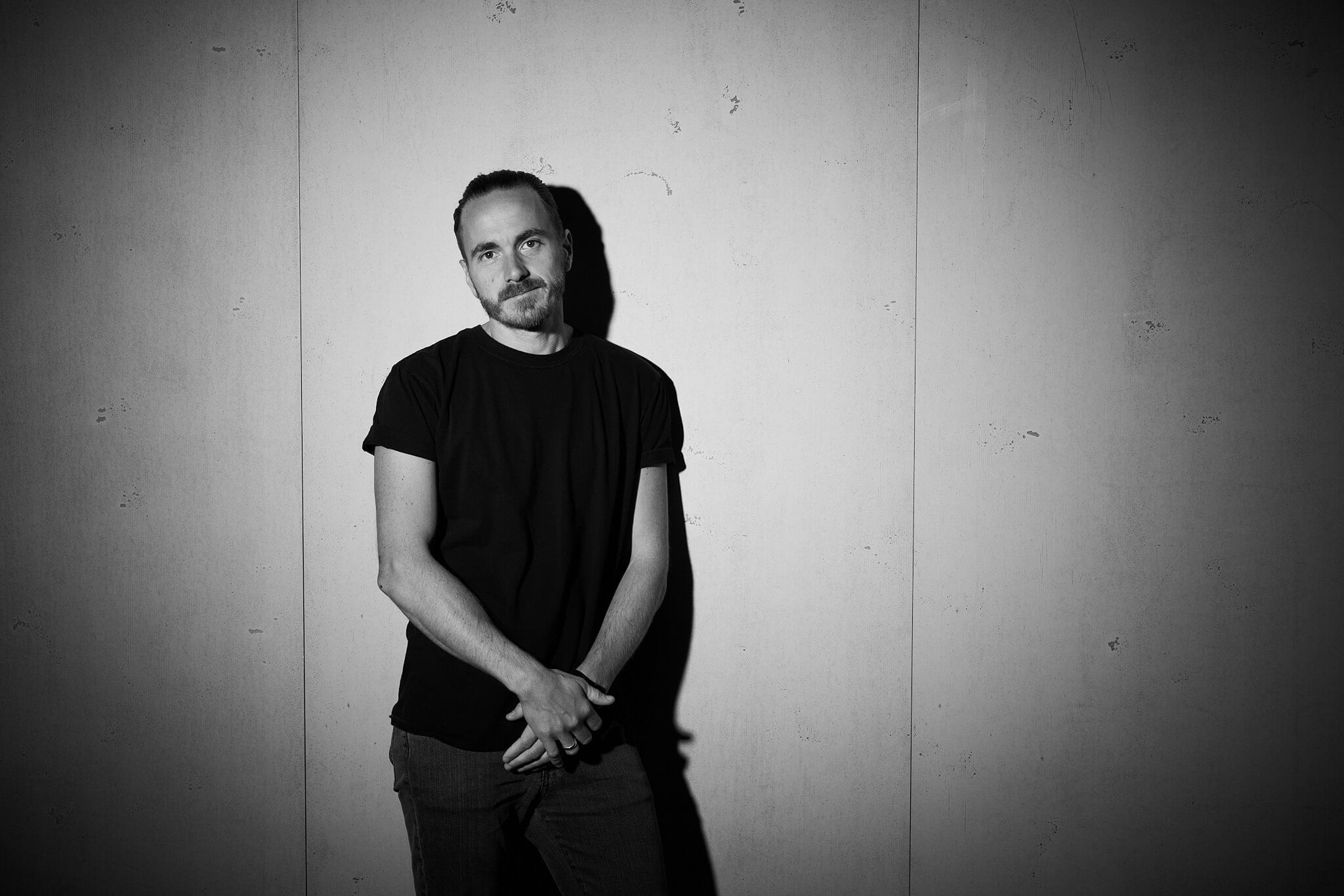 Image of Magnus Eckert, the professional brand strategist and website expert from Frankfurt Germany leaning against a concrete wall.